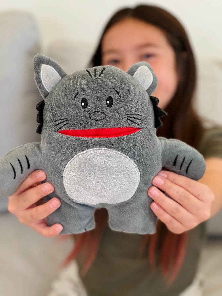 Person holding a gray plush cat toy with a red mouth